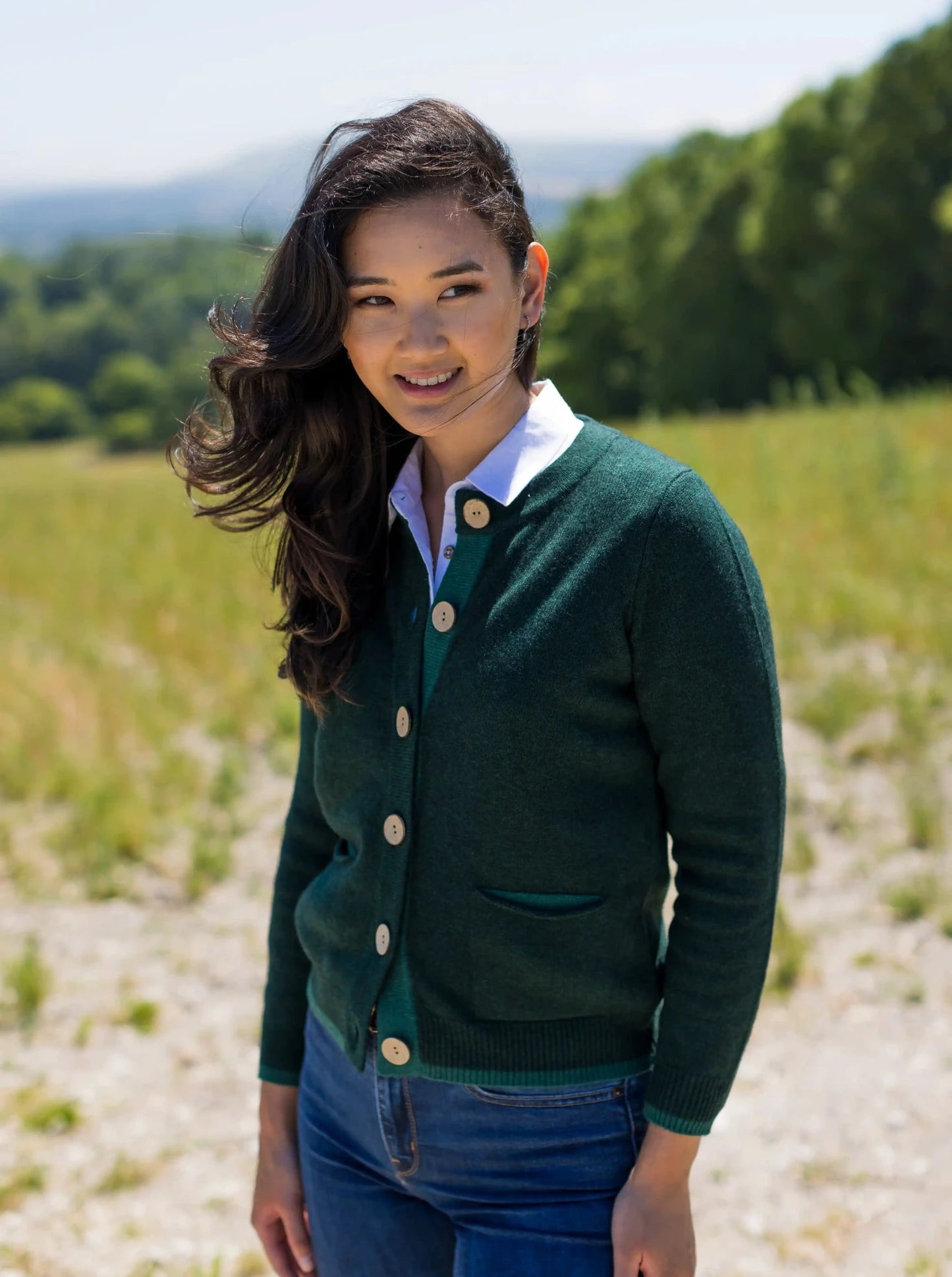 Model wearing cashmere and merino cardigan in green with pockets and large coconut buttons by Misty Cashmere