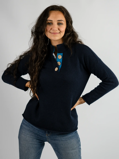 front profile of high collar jumper in cashmere merino wool in navy and turquoise with large coconut buttons from misty cashmere