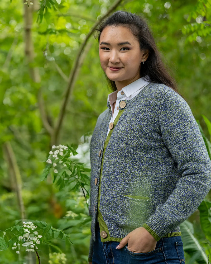 Woman wearing a blue and green cashmere knitted cardigan in a garden setting