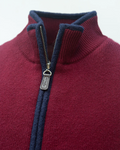 Close-up of a burgundy gilet with a zipper and navy boiled wool trim and discreet 'Misty' zip pull tag