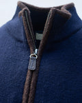 Close-up of a navy blue gilet with a brown boiled wool zip trim