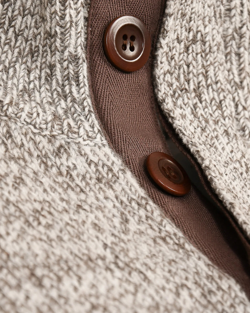 Close-up of cashmere and merino jumper in grey marl showing detail with brown corozo buttons 