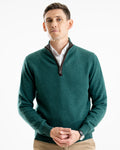 Man wearing a green sweater with a brown boiled wool trim to the zip with a white shirt underneath on a white background