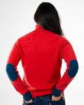 back view of woman wearing orange roll neck jumper with navy cuffs and elbow patches