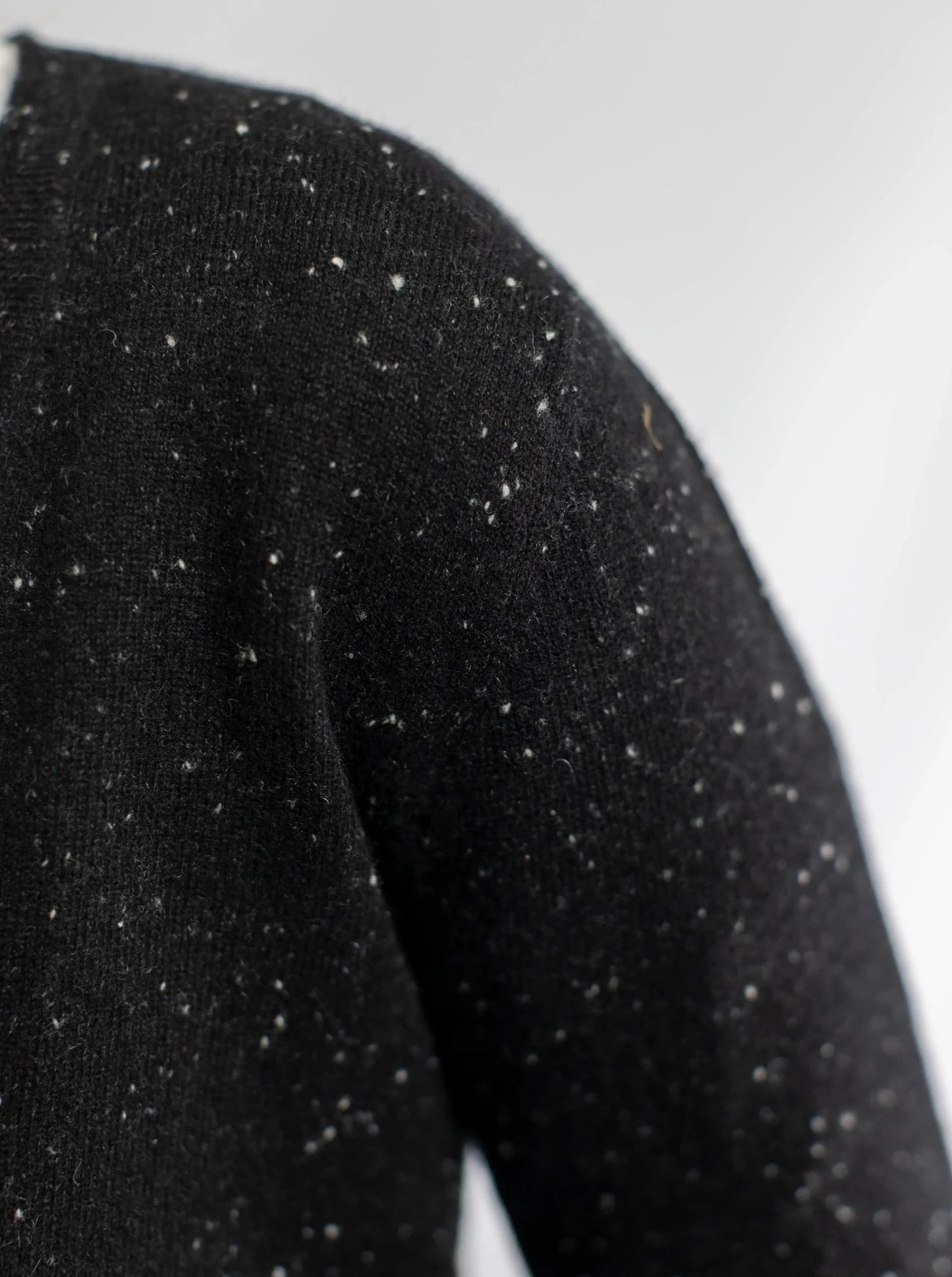 Detail of the black pure cashmere cardigan from Misty Cashmere showing the white fleck.