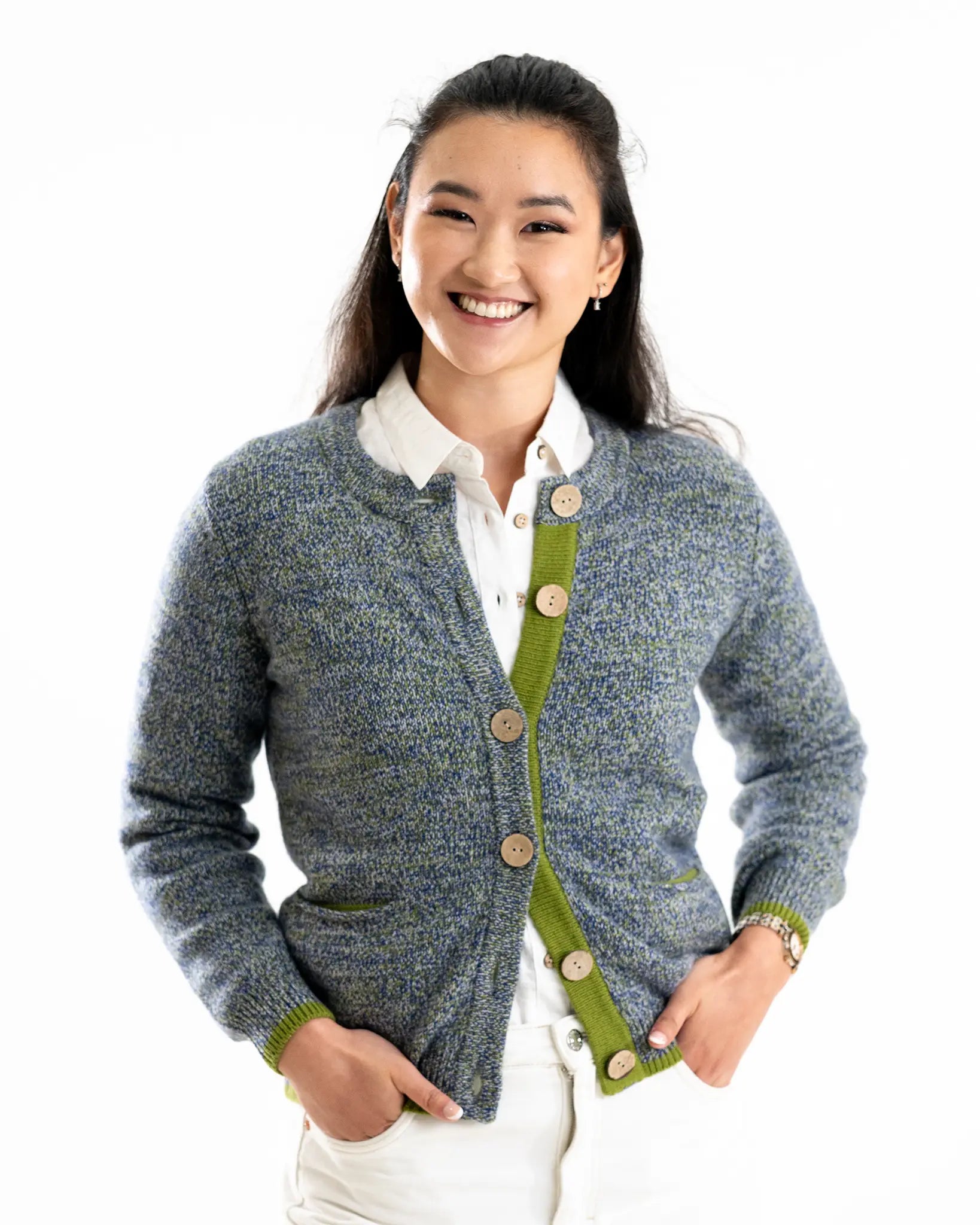 Woman wearing a blue and green cashmere cardigan with a white shirt on a white background