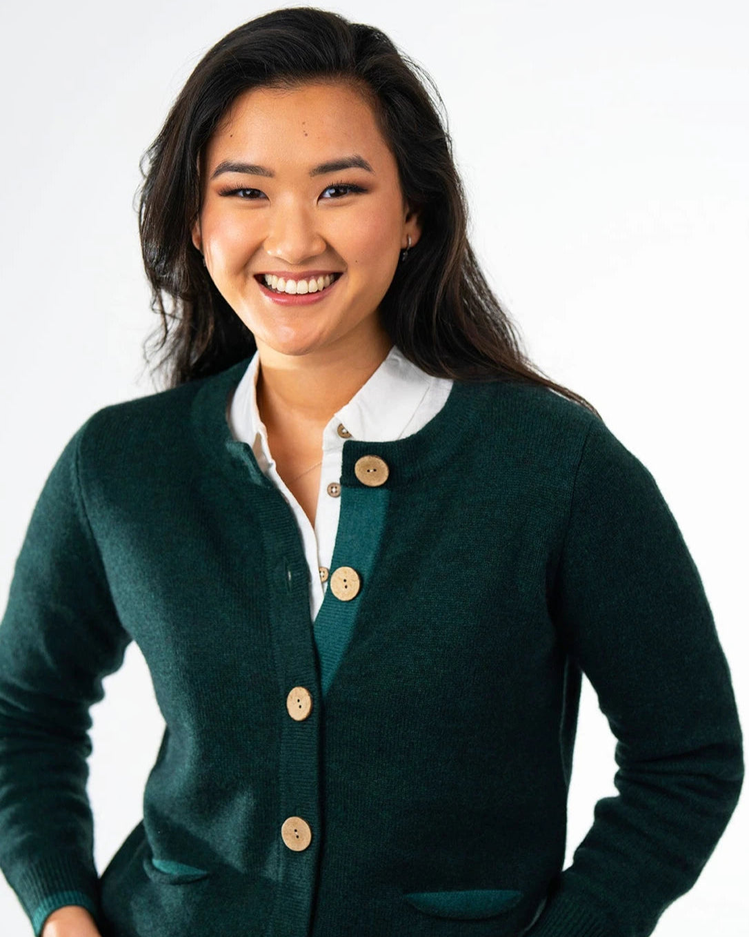 Model wearing green pocket cardigan with large coconut buttons
