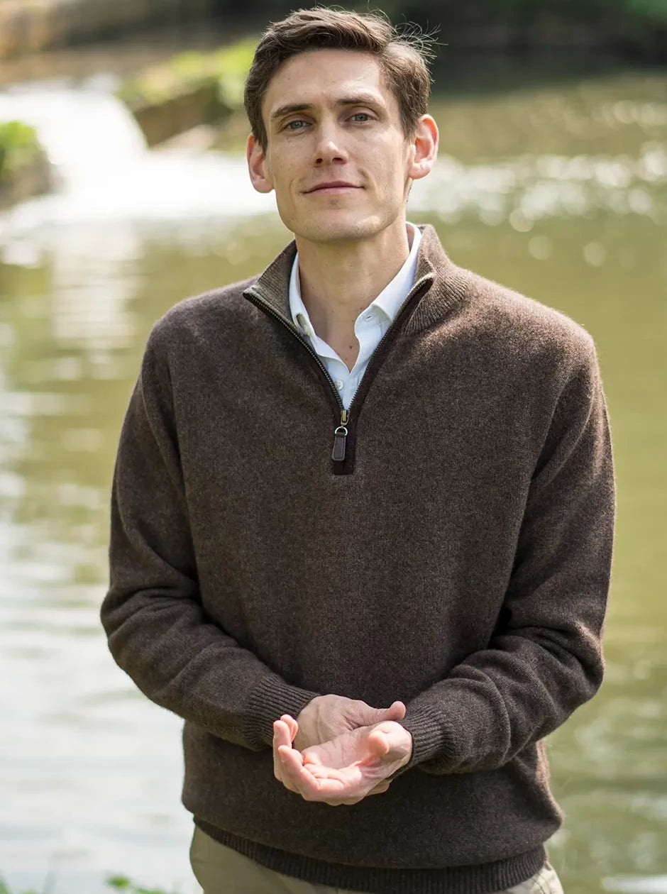 men's quarter zip neck jumper in undyed natural sustainable yak yarn with boiled wool trim next to river in the countryside by misty cashmere