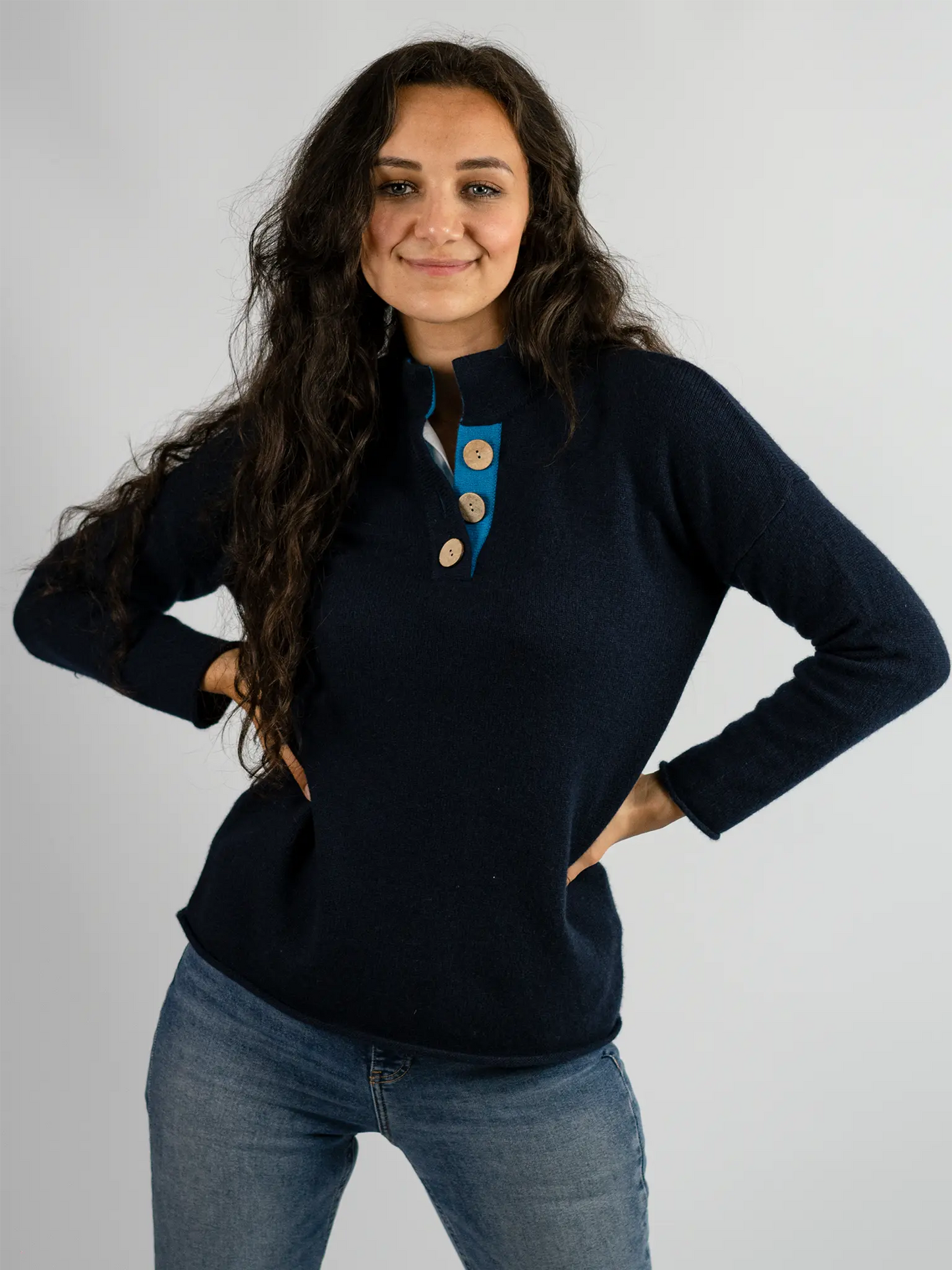 front profile of high collar jumper in cashmere merino wool in navy and turquoise with large coconut buttons from misty cashmere