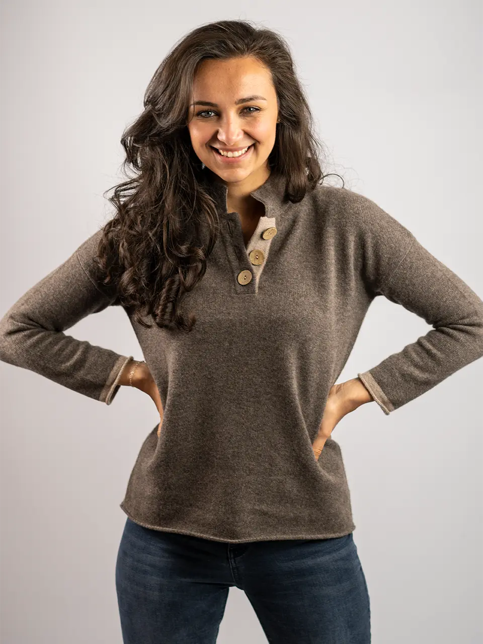 woman standing wearing high collar jumper in merino wool with coconut buttons